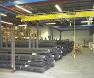 Under Hung or Under Running bridge cranes for sale by AMCHoist. An Under Hung or Under Running bridge crane from AMCHoist set up in a warehouse.